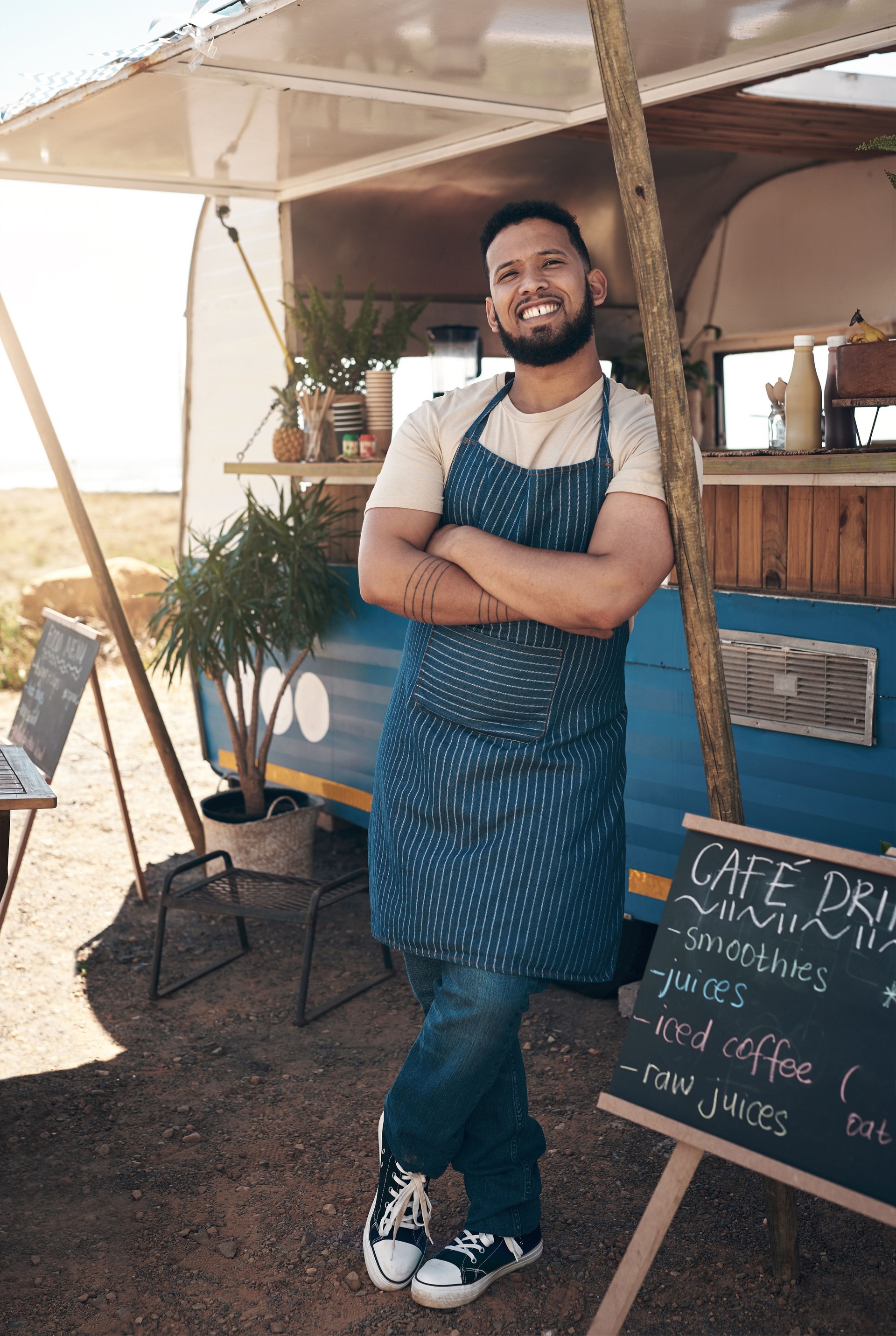 Shot of a young businessman standing outside of his food truck